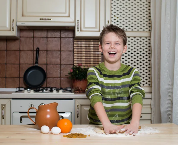 Niño en la cocina preparando la masa con balanceo . — Foto de Stock