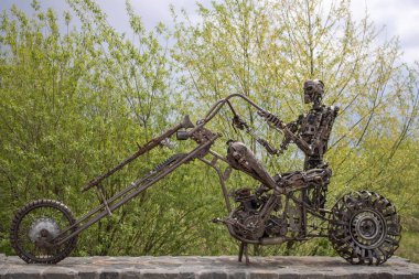 Filmdeki motosikletli Terminatör heykeli. Otomobil parçalarından yapılmış demir iskelet robot ve motosiklet. Hurda metalden sanat nesneleri.