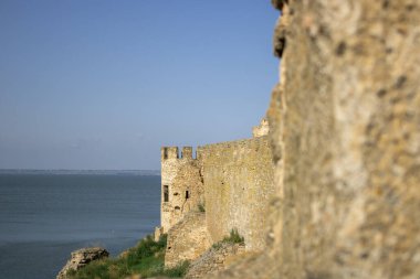 Mavi gökyüzüne karşı denizden gelen ortaçağ savunma kalesinin görüntüsü. Antik kale ve kale duvarlarının kuleleri. Akkerman 'ın tarihi kalesinin arkeolojik kazıları.