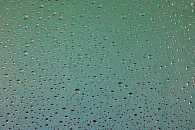 Suyun dokusu soluk yeşil bir arkaplanda cama düşer.. 