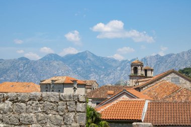 Dağların ve mavi gökyüzünün arka planında bulunan eski Kotor Montenegro kasabası. Açık bir yaz gününde, dağların arka planına karşı parlak, güzel bir manzara..