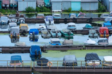 Birçok renkli sürat tekneleri rıhtıma park etti. Su nakli için yer. Sürat tekneleri için garaj sistemi. Marina gemi istasyonuna demirlemiş. Nehir kıyısındaki turizm beldesi.