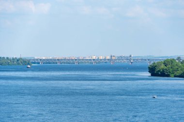 Sağ ve sol kıyıları birbirine bağlayan pitoresk nehir boyunca uzanan yol ve demiryolu köprüsü manzarası. Tren, kargo ve yolcu taşımacılığı için Panorama Köprüsü. Altyapı Dnipro Ukrayna.