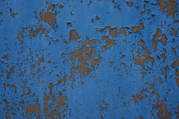 an old iron wall with old paint that has become dull and rusty due to time and weather conditions.  close-up.  can be used as a photo background