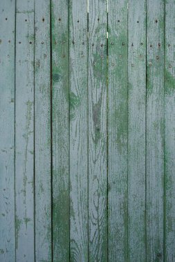 Ahşap çit dokusu. Çit yeşile boyanmış. Eski bir çitin boyasını soyuyordu. Eski ahşap doku. Fotoğraf bir fotofon, bir doku olarak kullanılabilir.