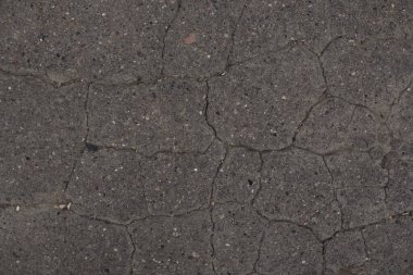 Beton dokuyu kapat. Beton yüzeyde ilginç bir doku yapısı oluşturan küçük çatlaklar var. Gölgelerin geçişi. Fotoğraf arkaplanı olarak kullanılabilir