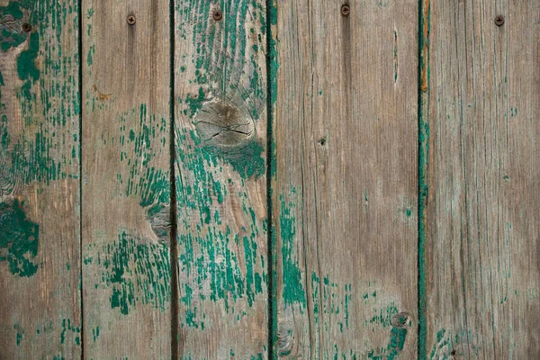 texture of a wooden fence.  fence painted green.  peeling paint on an old fence.  old wood texture.  photo can be used as a photophone, as a texture