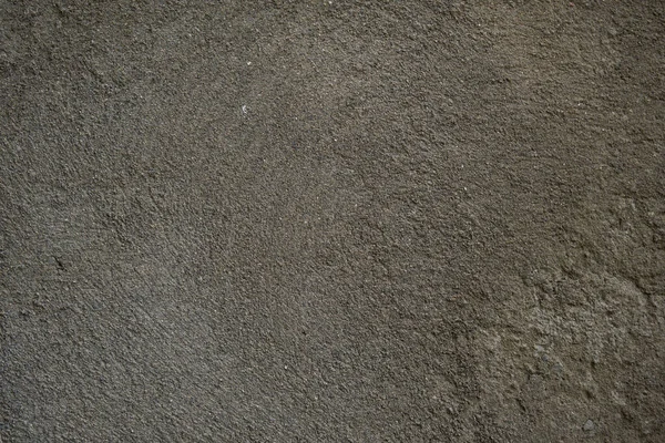 Beton dokuyu kapat. Beton yüzeyde ilginç bir doku yapısı oluşturan küçük çatlaklar var. Gölgelerin geçişi. Fotoğraf arkaplanı olarak kullanılabilir