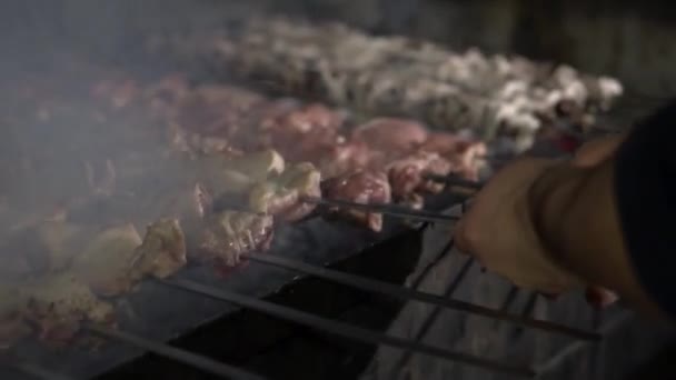 グリルクローズアップ 料理人は肉をグリルの上でひっくり返し 両側に揚げます 肉から石炭にジュースが落ち石炭から煙が立ち上がり — ストック動画