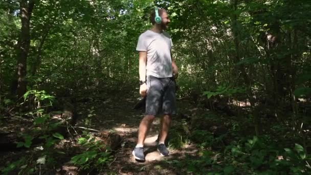 Jeune Homme Short Blanc Doux Gris Avec Écouteurs Traverse Forêt — Video