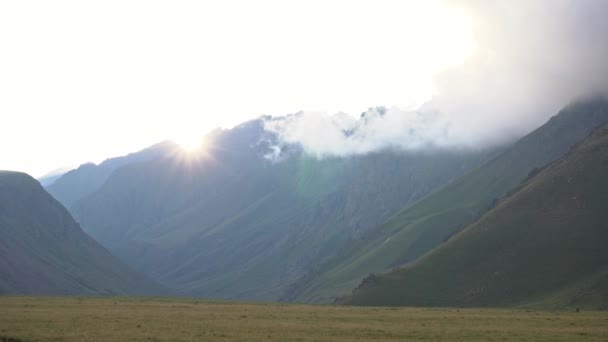 山の中の夕日 ビデオの中で太陽は遠くの山の後ろに沈みます 山の向こうから美しいサンビームが見える 夏だエルブロス — ストック動画