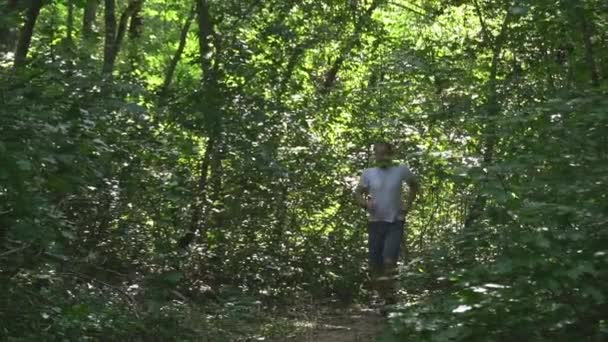 Young Man White Meek Gray Shorts Headphones Runs Forest Summer — Vídeo de Stock