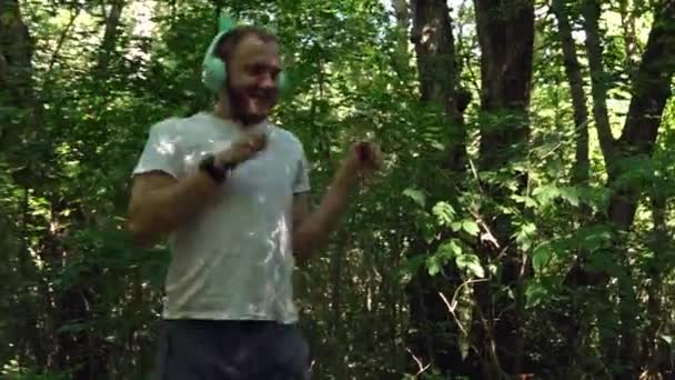 Young Man Jogging Morning Forest Stands Path Funny Children Headphones — Vídeo de Stock