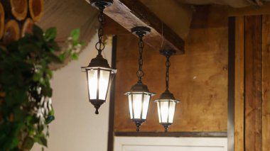 İç çekimler, yakın plan. Restorandaki güzel demir fenerler tavandaki ahşap kirişe asılı..