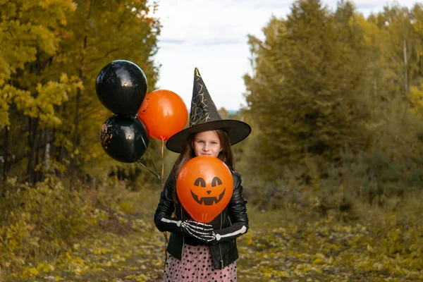 Забавная Девочка Костюме Ведьмы Хэллоуин Черными Оранжевыми Шариками Фоне Осеннего — стоковое фото