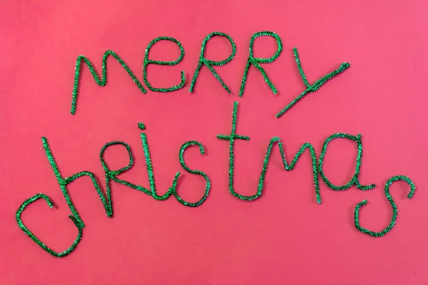 Inscription in green letters Merry Christmas on a red background. — Stock Photo, Image