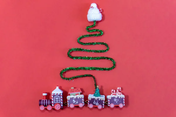 Christmas composition. Gifts, creative Christmas tree, sweets, decorations on a red background. — Stock Photo, Image