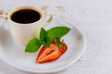 Beyaz ahşap masada çilekli sade kahve. Kapat..