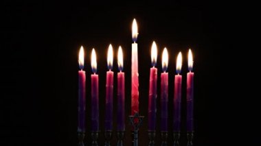 Siyah arkaplanda pembe mumları yakın. Yahudi bayramı bayramı..