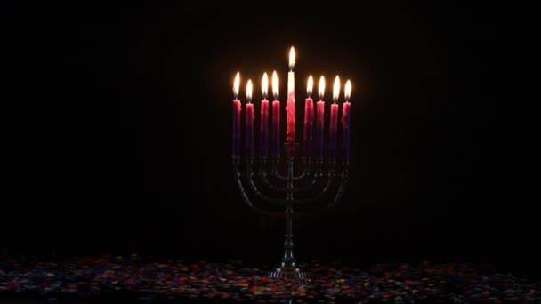 Burning menorah with pink candles and confetti on black background. Jewish holiday Hanukkah. — Stock Video