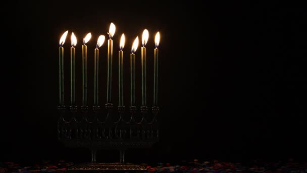 하누카 보석 휴가를 위해 어두운 곳에서 촛불을 켜고 있는 메노라. — 비디오