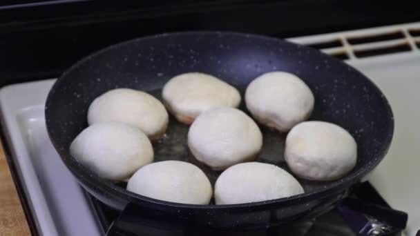 Freír y voltear rosquillas redondas en aceite caliente . — Vídeo de stock