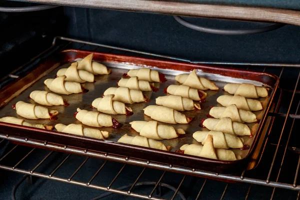 Elektrikli fırında çiğ hilal kurabiyeli fırın tepsisi.