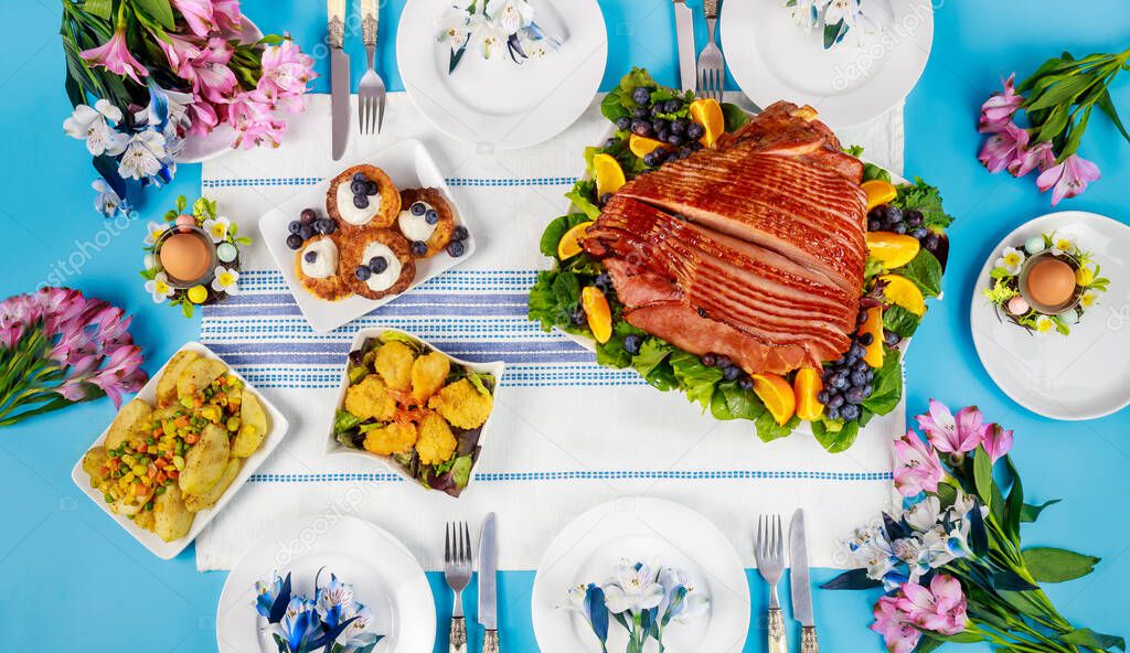 Festive Easter table with ham, salad and pancakes. Easter dinner.