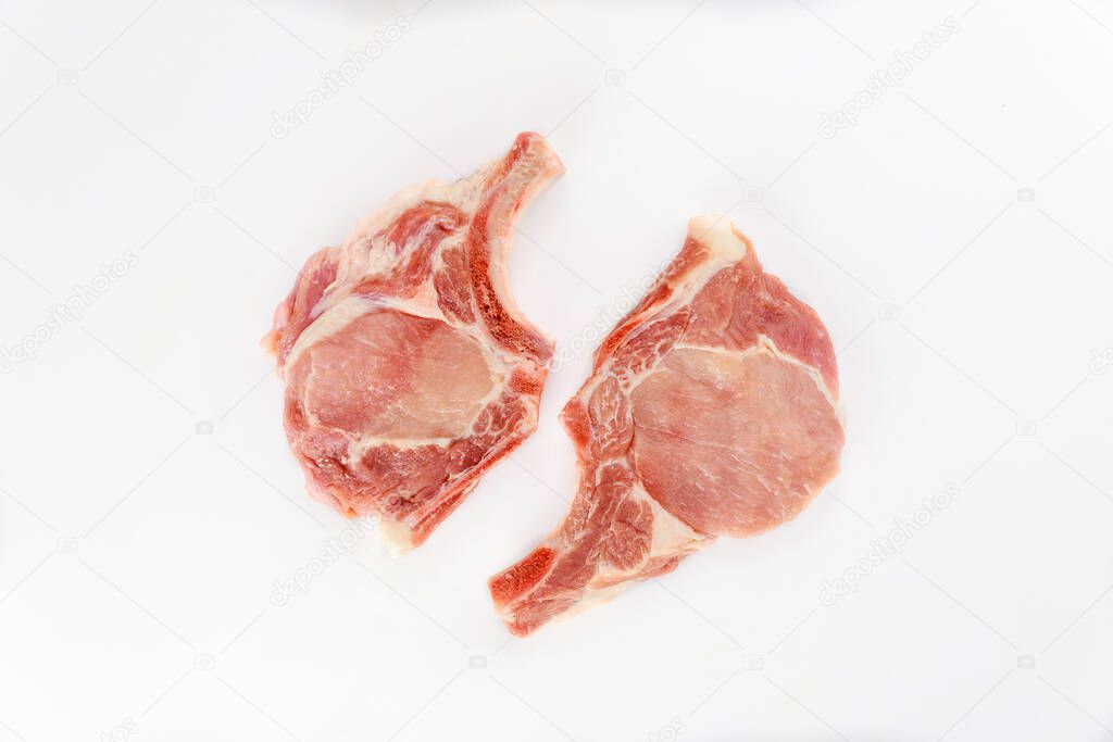 Two pieces of raw pork chops bone in isolated on white background. Top view.