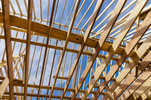 Wooden roof truss on a clear sky background