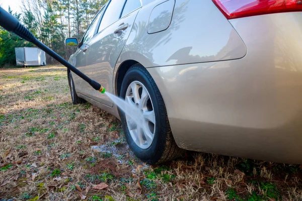 During wheel washing, a water sprayer is used to wash the car.
