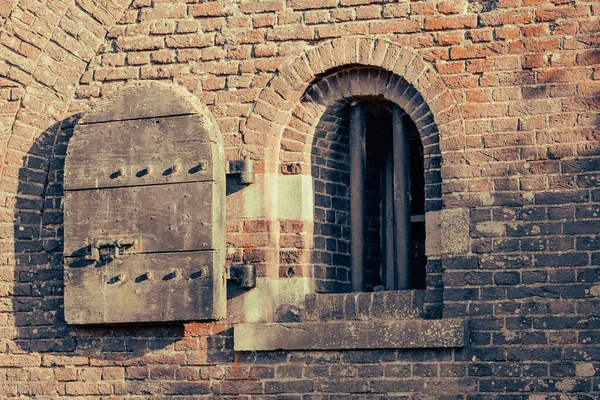 Ściana twierdzy z oknem i kratami — Zdjęcie stockowe