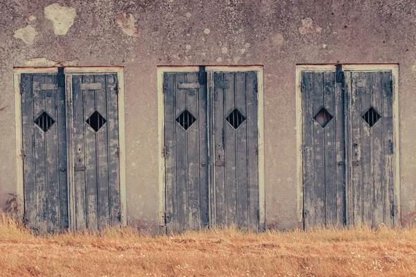 Ściana twierdzy z drewnianymi drzwiami z kratami — Zdjęcie stockowe