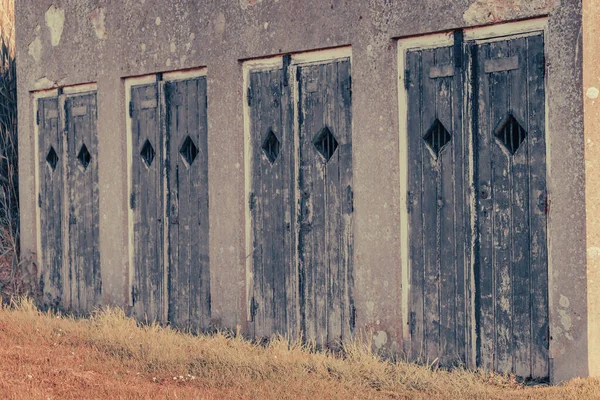 Ściana twierdzy z drewnianymi drzwiami z kratami — Zdjęcie stockowe