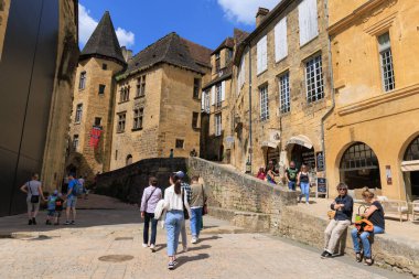Sarlat-la-Caneda, Fransa - 30 Nisan 2022: Fransa 'da Sarlat-la-Caneda, Dordogne, Perigord rgeion' a giden manzaranın tadını çıkaran turist