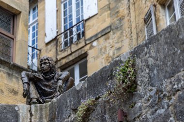 Sarlat-la-Caneda, Fransa - 30 Nisan 2022: Le Badaud Seyirci Heykeli Sarlat 'ın tarihi merkezindeki resim ortaçağ meydanına bakıyor.