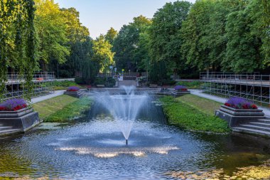 Fountains and large classic pond surrounded with flowers in public park Noorderplantsoen in Groningen city in The Netherlands