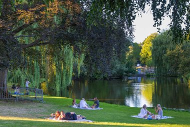 Groningen, The Netherlands - August 11, 2022: People relaxing in public park Noorderplantsoen in Groningen city in The Netherlands at sunny evening in summer