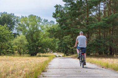 Tourist cycling along the green belt near Domitz former inner-German border and death strip between East and West Germany during the cold war. Nowadays a major biosphere park in Germany.