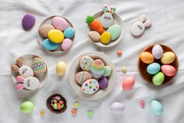 Mutlu Paskalyalar. Masada Paskalya yumurtası, tatlı ve kurabiye var. Düz yatıyordu. Tablo üstü görünümü.