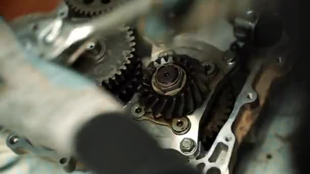 A man tightens the bolts in the ATV motor with a screwdriver and a wrench — Stock Video