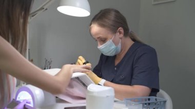 Tırnak uzatma servisi. Manikürcü, manikür jeli tırnağı uzatması yapıyor