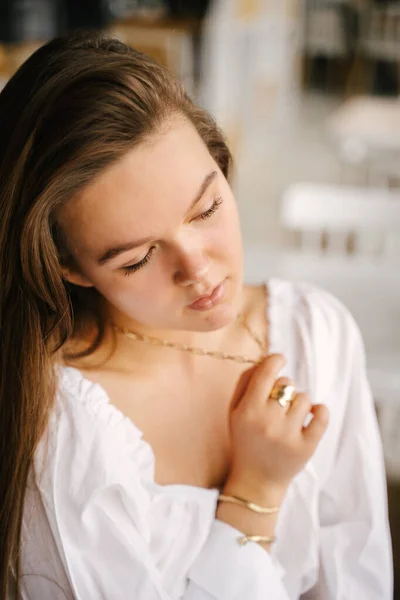 Uma Jovem Mulher Vestido Branco Senta Frente Janela Segura Sua — Fotografia de Stock