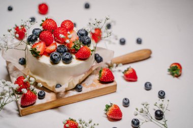 Beyaz arka planda yaban mersinli güzel çilekli pasta.