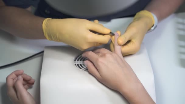 Manicure em luvas de látex com pinças de metal corta a cutícula — Vídeo de Stock