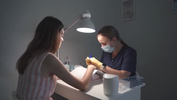 美容师用修剪过的指甲轻轻去除客户的旧指甲 — 图库视频影像