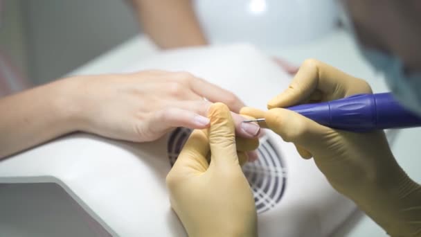 Nageltekniker tar bort nagelbanden med en elektrisk trimmer — Stockvideo