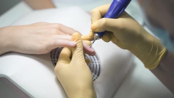 Nageltekniker tar bort nagelbanden med en elektrisk trimmer — Stockvideo