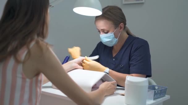 La manicura hace la forma de las uñas con un archivo duro para el cliente — Vídeo de stock