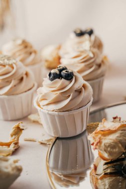 Kremalı beyaz kremalı ve yaban mersinli kekler, üst manzara, yakın plan, aynalı